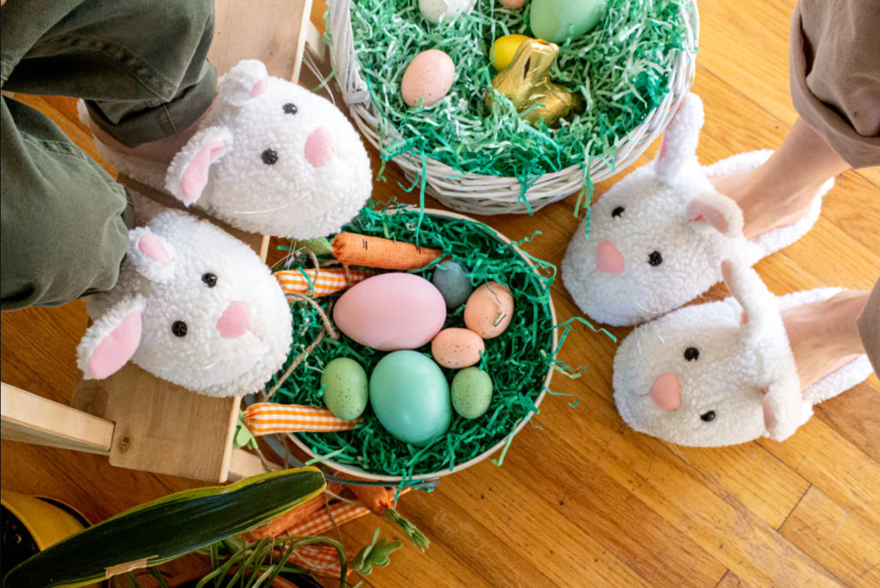 Two people wearing bunny slippers with Easter baskets 