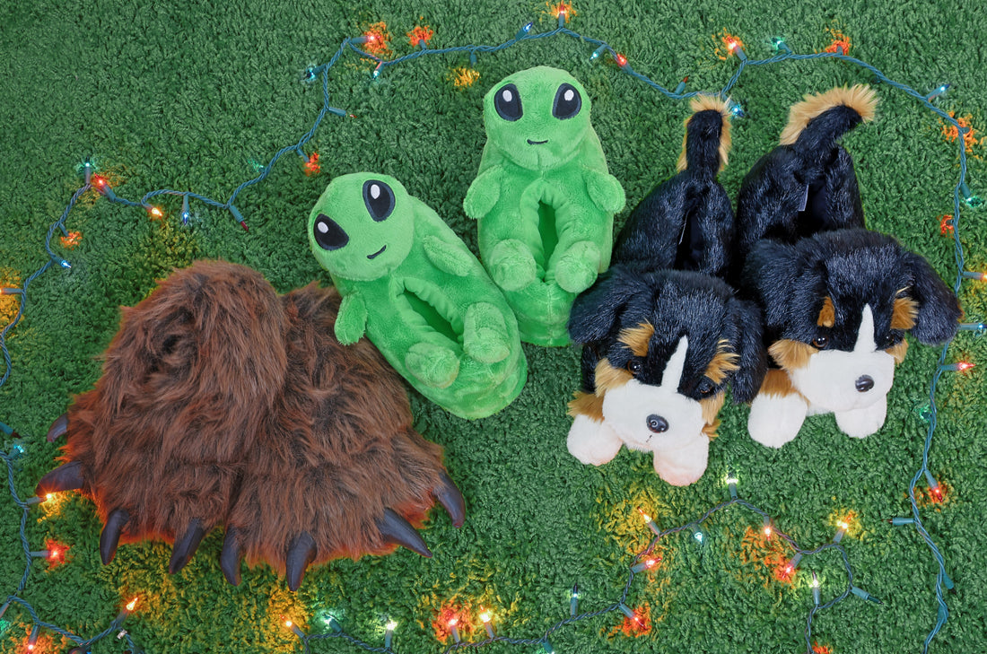Three pair of slippers on a green carpet, surrounded by holiday lights