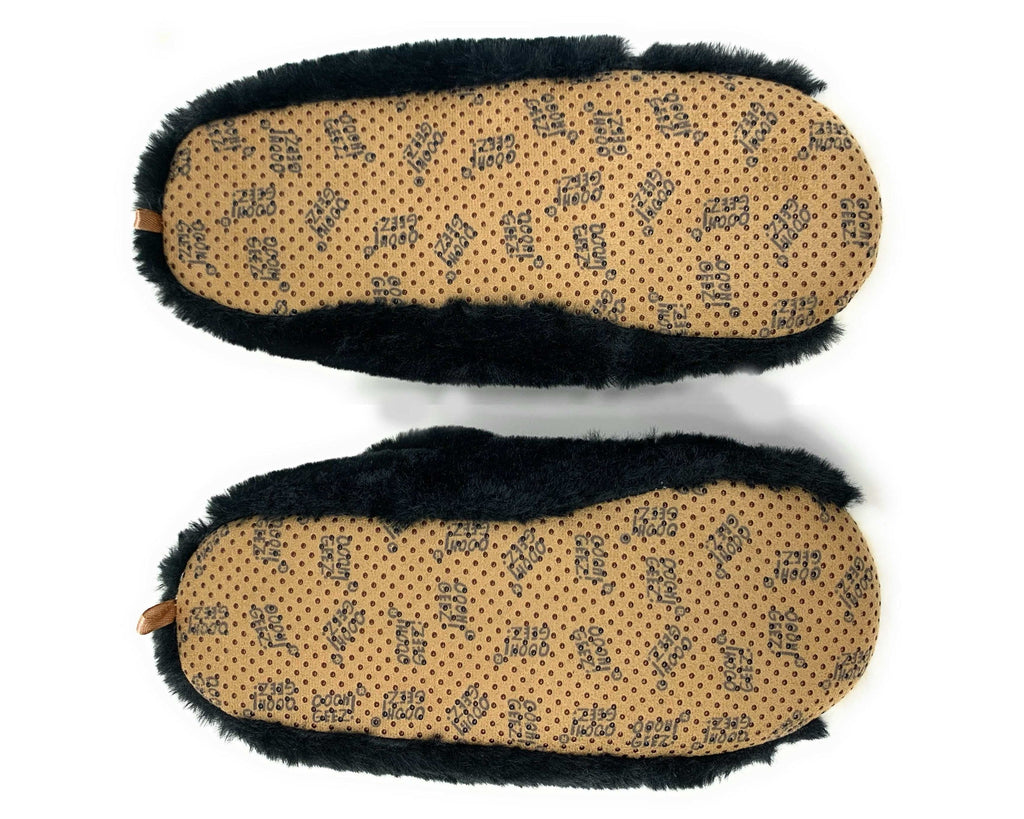 A pair of slippers shown from the bottom, featuring a tan footbed with a repeating black brand name pattern and black faux-fur trim along the sides.