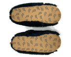 A pair of slippers shown from the bottom, featuring a tan footbed with a repeating black brand name pattern and black faux-fur trim along the sides.