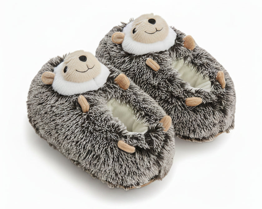 A pair of plush hedgehog slippers with gray and white faux fur, tan paws, and a face on the top, shown on a white background.
