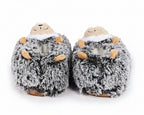 A pair of plush hedgehog slippers in gray and white faux fur with small tan accents on the paws and snout, shown against a plain white background.