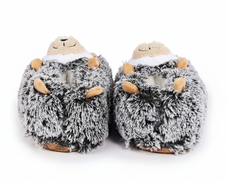 A pair of plush hedgehog slippers in gray and white faux fur with small tan accents on the paws and snout, shown against a plain white background.