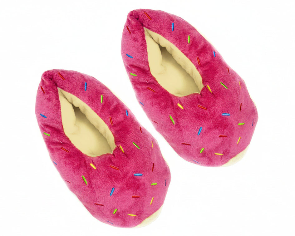 A pair of plush donut slippers in bright pink with multicolored sprinkle details and a cream-colored lining, shown against a plain white background.