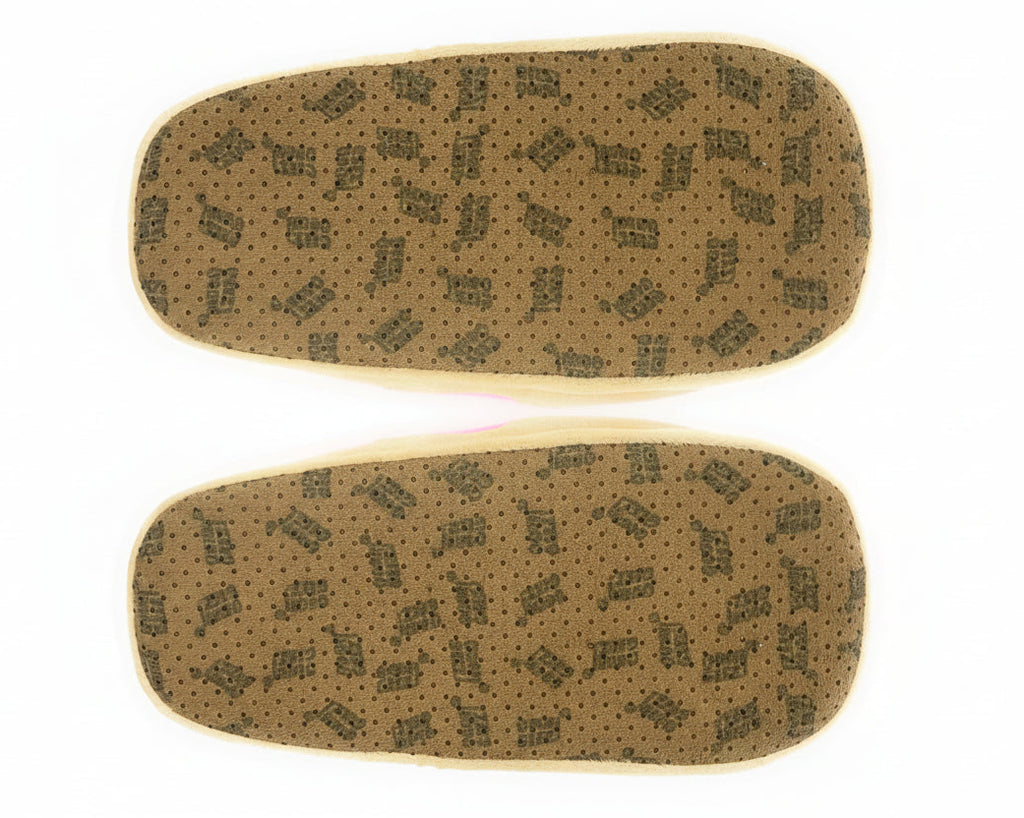 Pair of slippers seen from the bottom, showing faux suede soles with non-slip grips and a repeating brand name printed in black