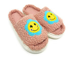 Pink slippers with smiley face designs on a white background