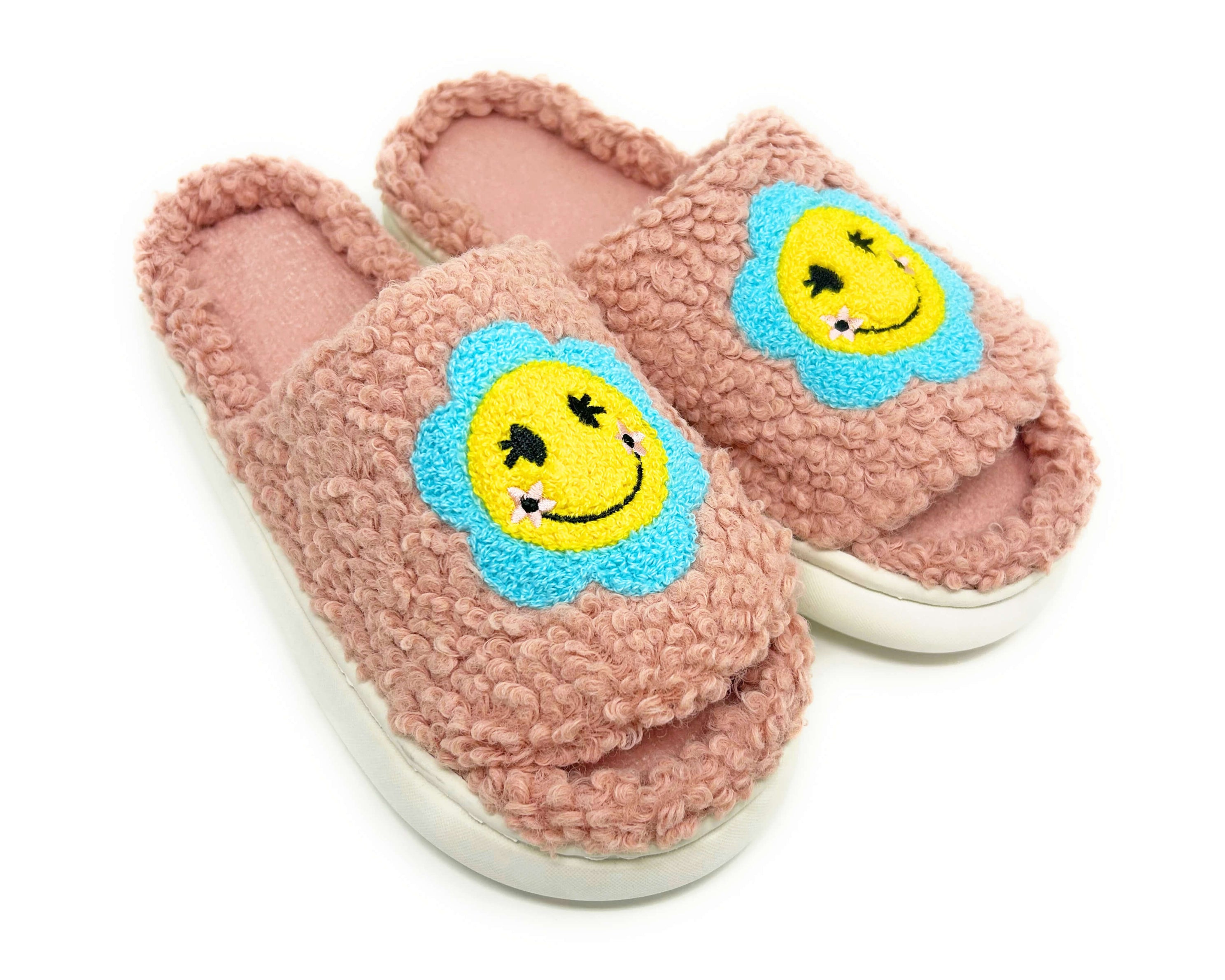 Pink slippers with smiley face designs on a white background