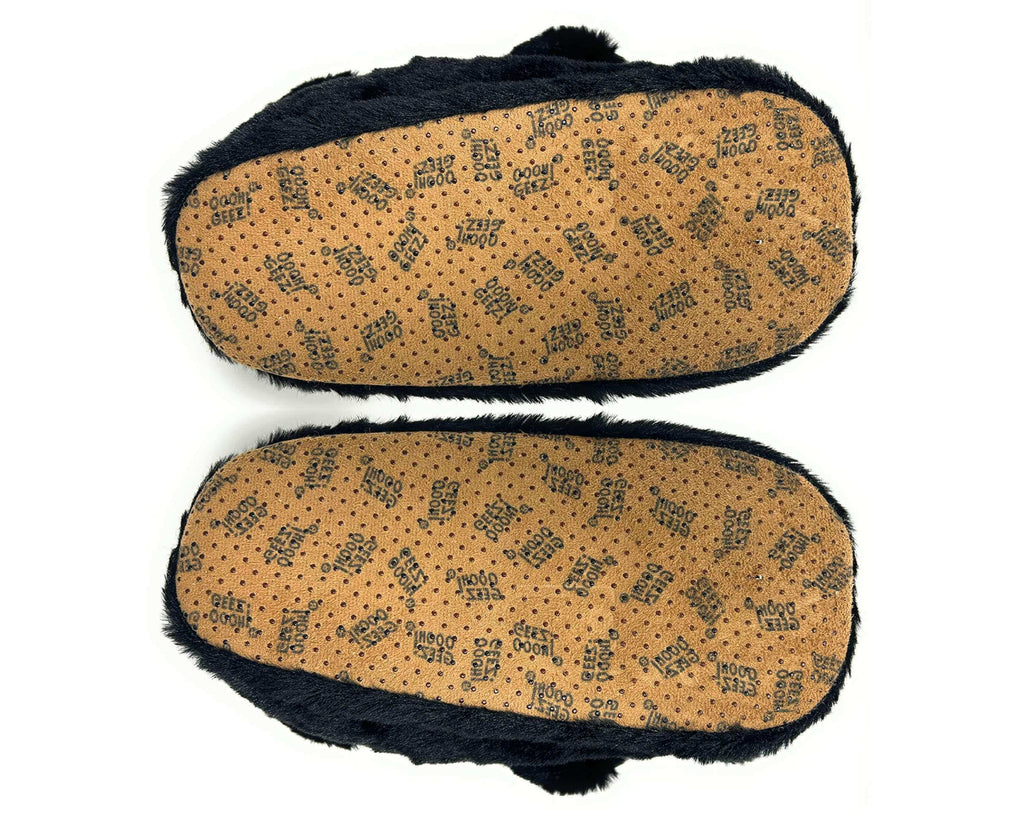 Pair of black bear slippers shown upside-down so that soles and non-slip grips are visible on a white background