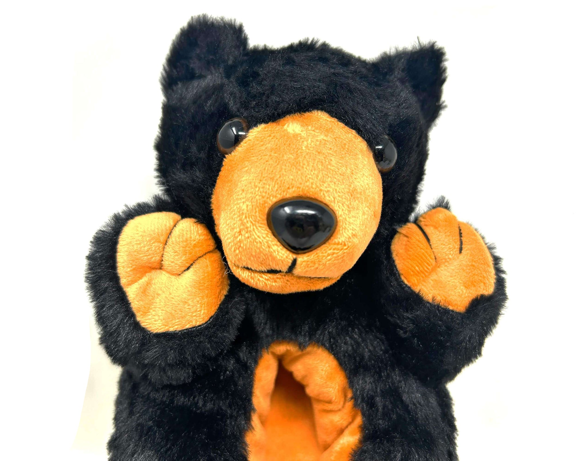 Black and orange plush bear slipper on a white background
