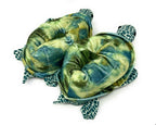 Two green plush turtle slippers on a white background