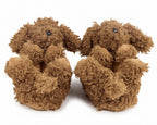 A pair of plush dog slippers in a curly brown faux fur material, featuring small black bead eyes and pinkish-tan paws and noses, set against a plain white background.
