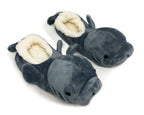 A pair of plush manatee-shaped slippers in dark gray with a cream sherpa lining, shown on a plain white background.