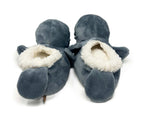 Pair of gray manatee slippers with white interior on a white background