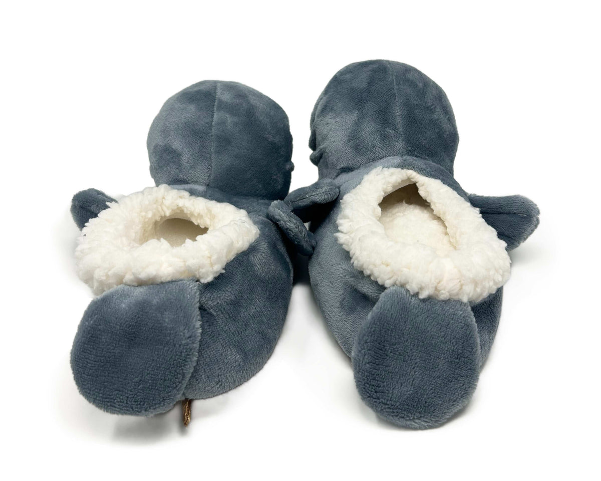 Pair of gray manatee slippers with white interior on a white background