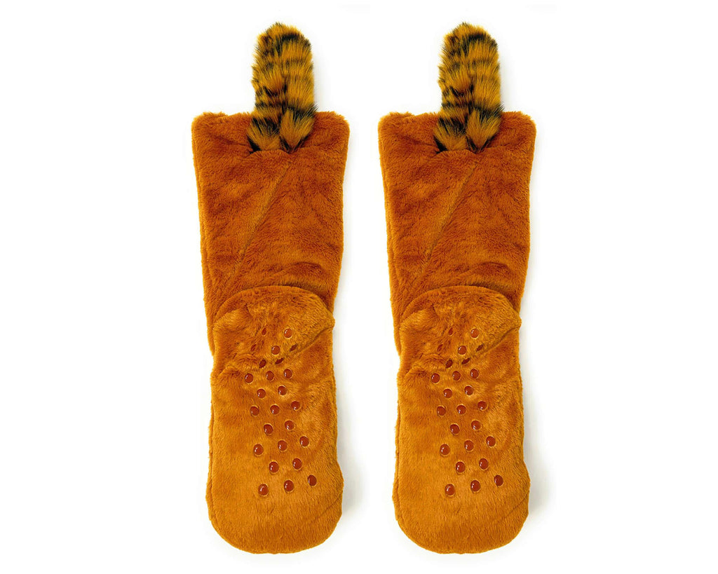 A pair of plush slipper boots in a warm rust-orange color, featuring textured grip dots on the soles and fuzzy animal-print tails. 