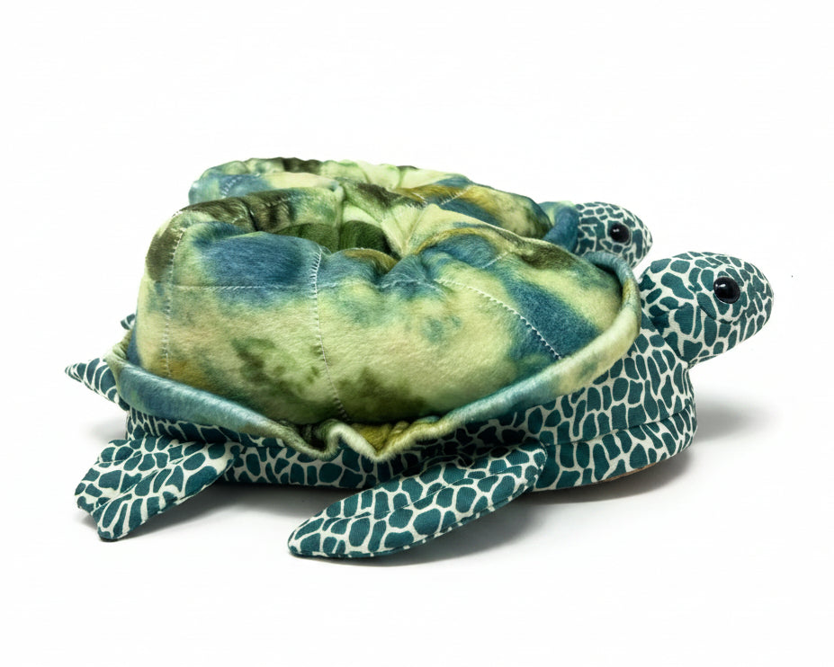 Plush turtle slippers with green and blue pattern on a white background