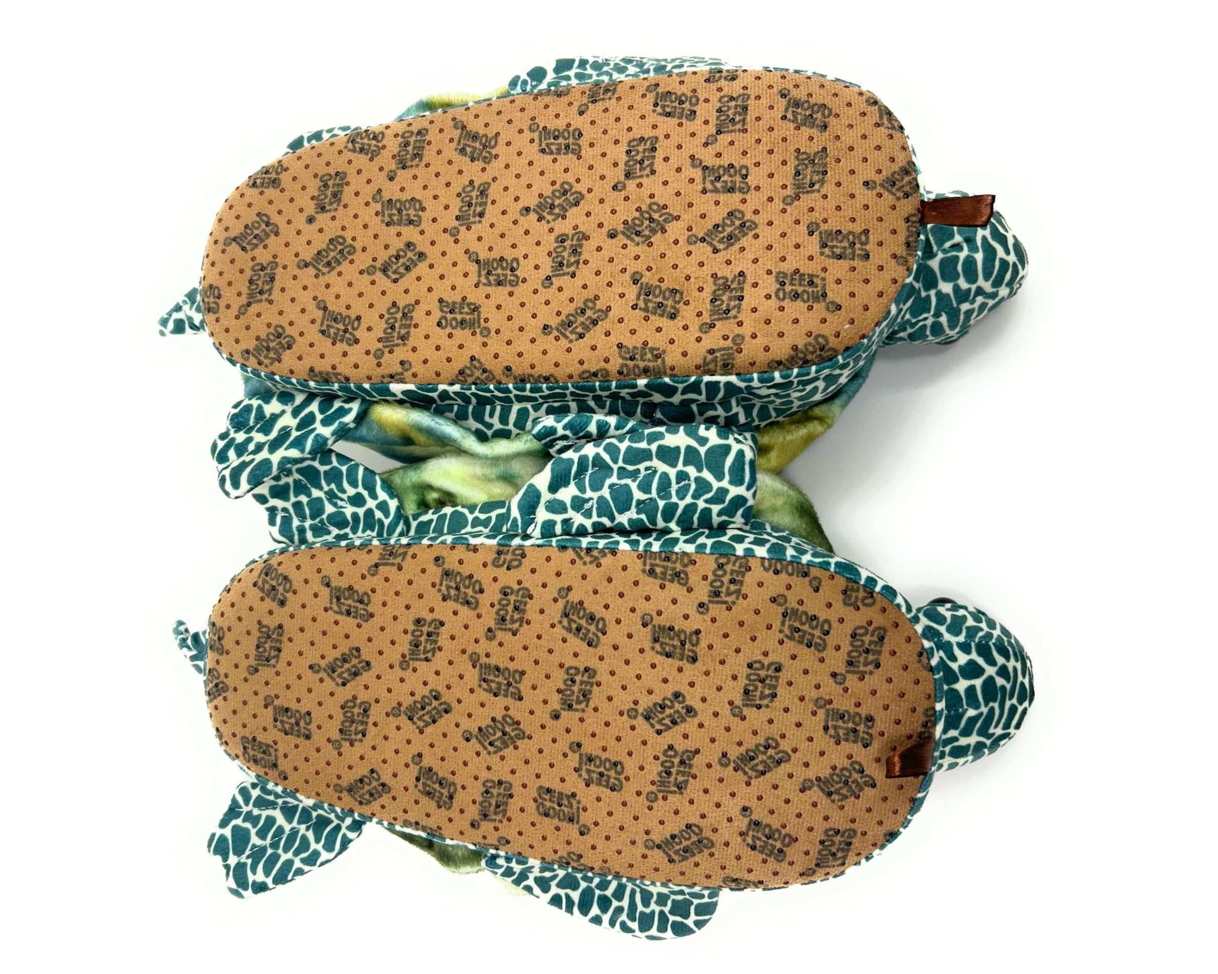 Two plush turtle slippers turned upside-down to show non-slip on a white background