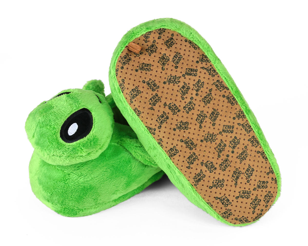 Green plush slippers shaped like aliens with a brown sole on a white background
