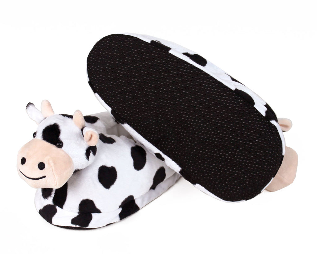Cow-patterned slippers on a white background, one is turned upside-down to show sole with non-slip grips