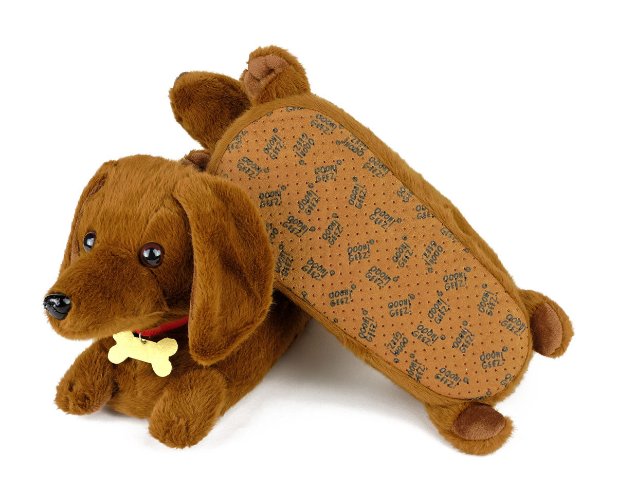 pair of plush dachshund dog slippers with one slipper upside down to show the sole, faux leather with non-slip grips
