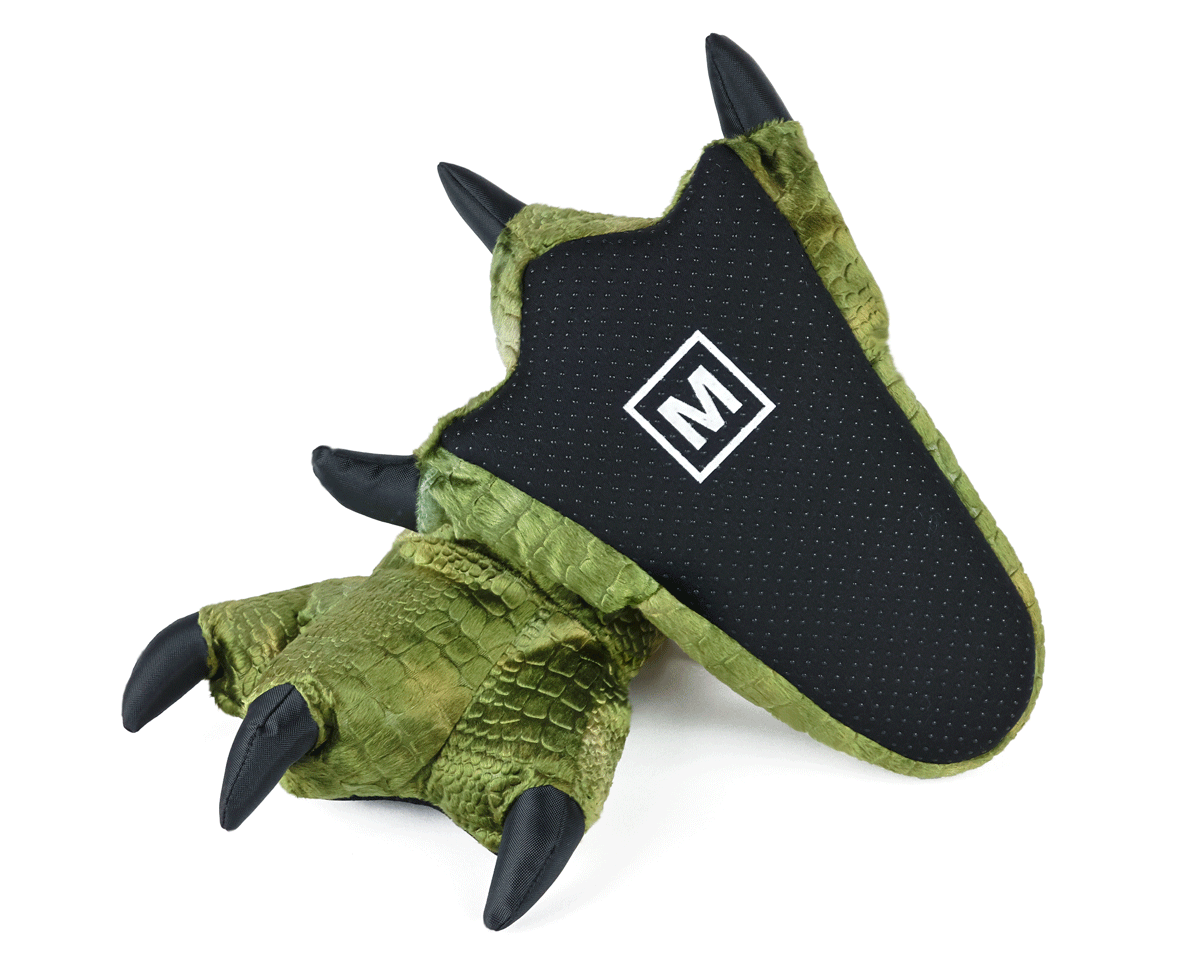 Pair of plush green dinosaur claw slippers, with one flipped upside down to show black fabric sole with non-slip grips.