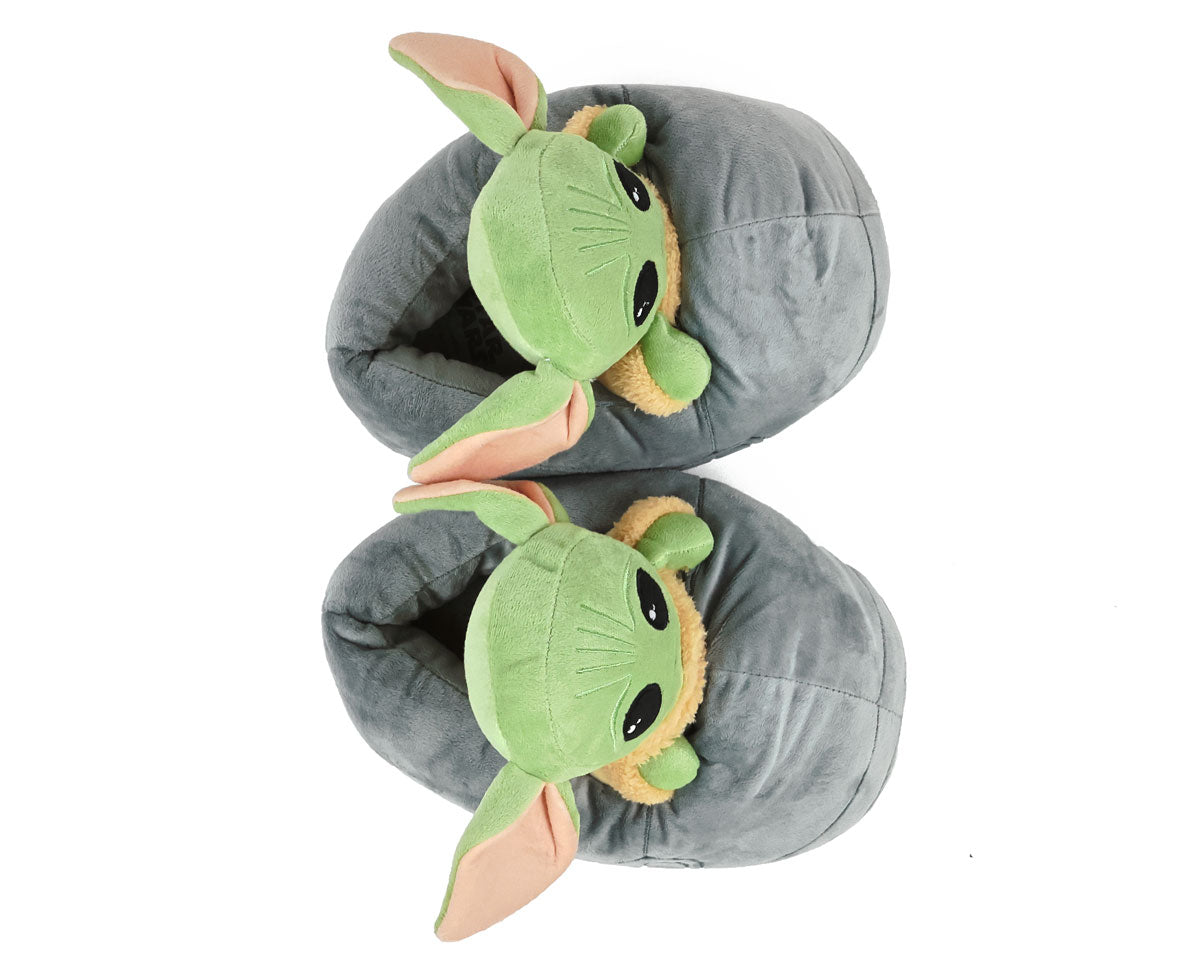 Top view of plush slippers shaped like the green Grogu character with big ears on a white background