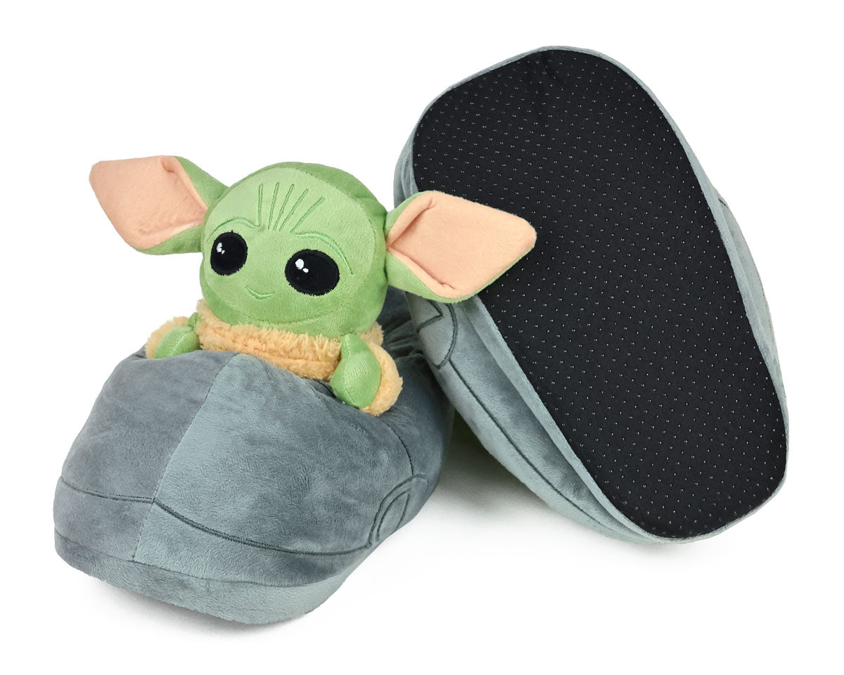 Pair of plush slippers shaped like the green Grogu character with big ears on a white background, one slipper is upside-down to show non-slip grips on sole