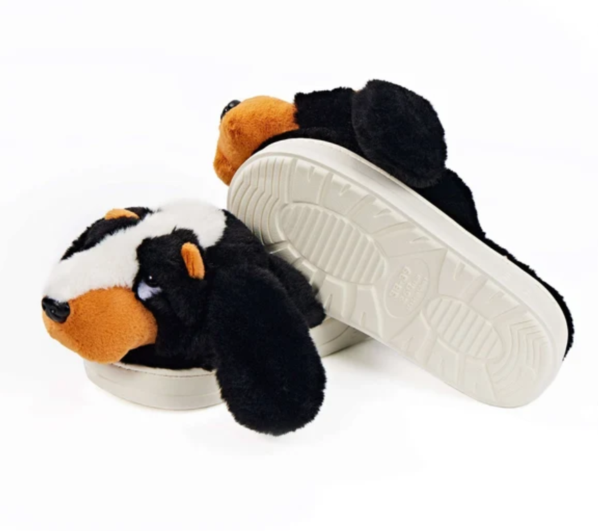 Pair of plush slippers shaped like hound dogs with brown white and black faux fur, long floppy ears, and molded soles.