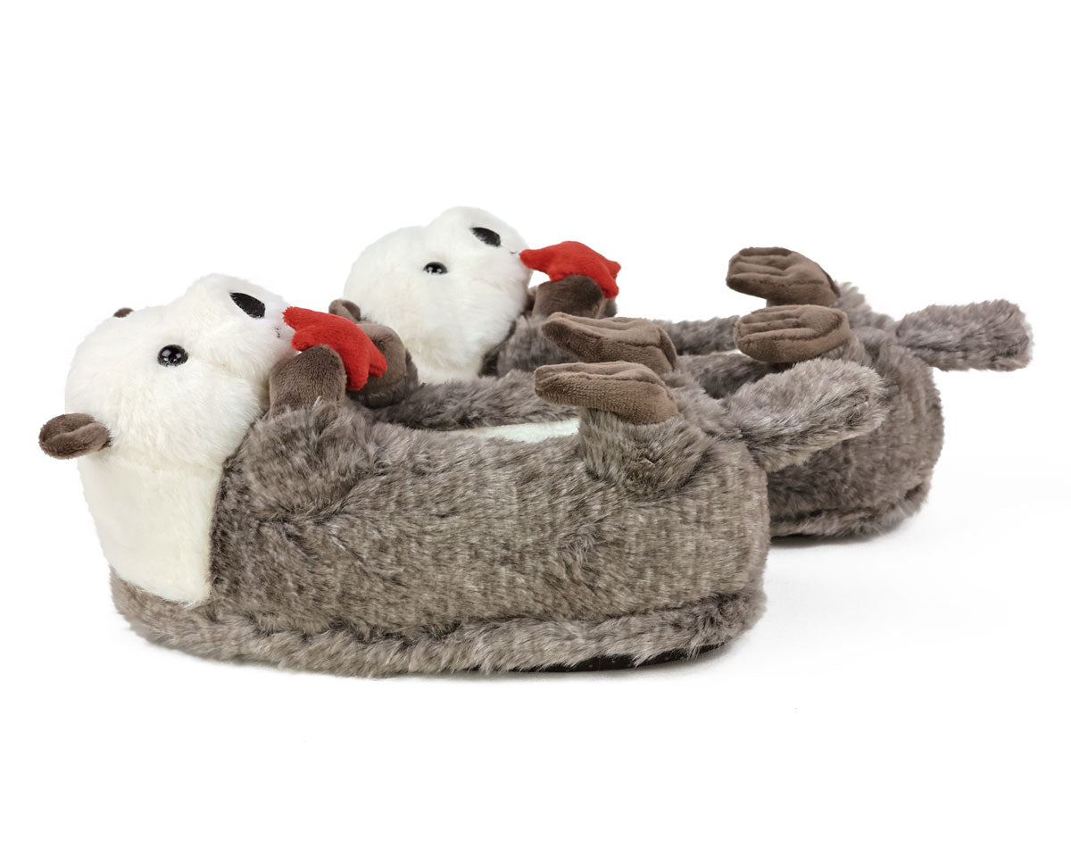 Pair of plush slippers with otter design on a white background, seen from the side