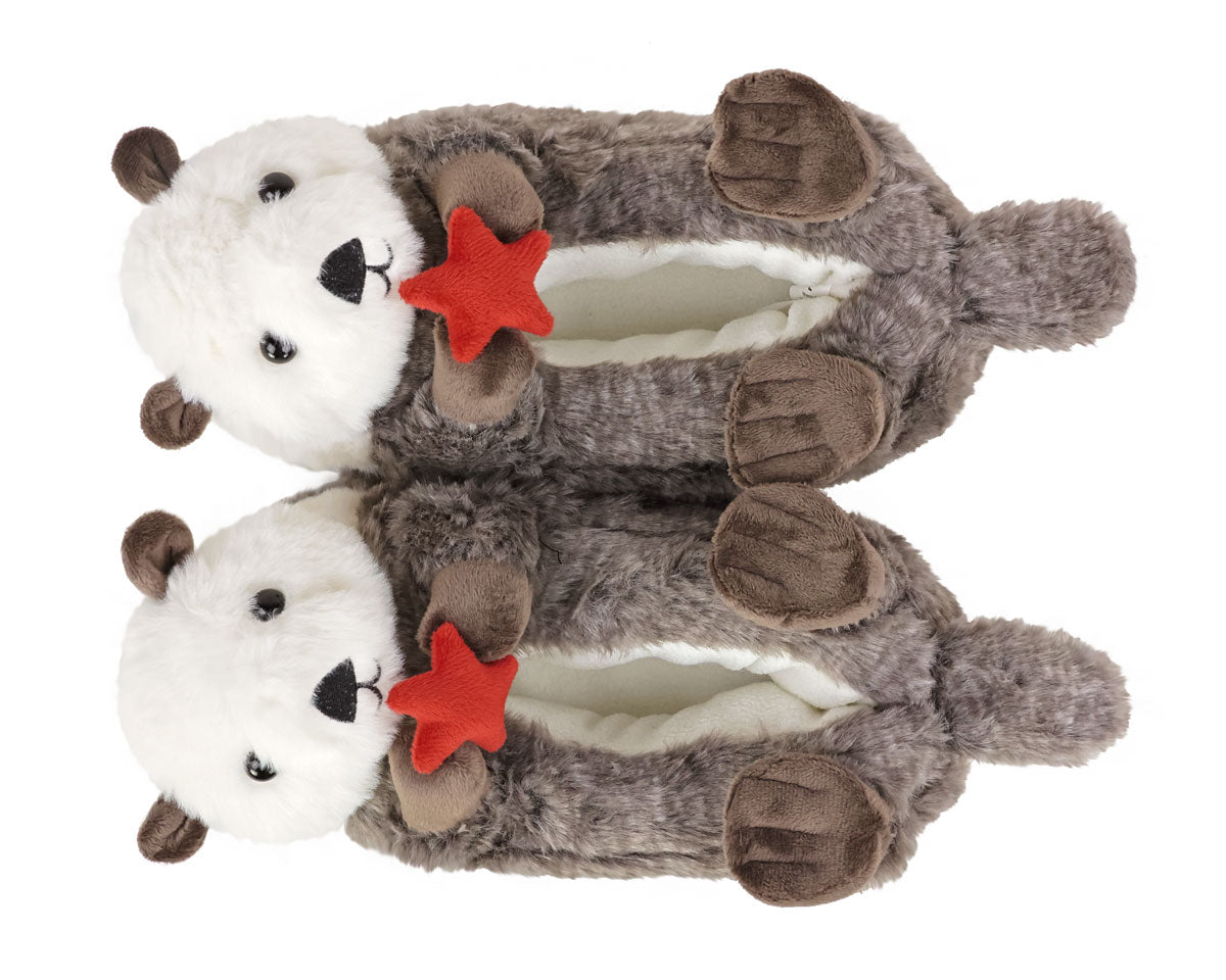 Pair of plush otter slippers holding red starfish on a white background, seen from above