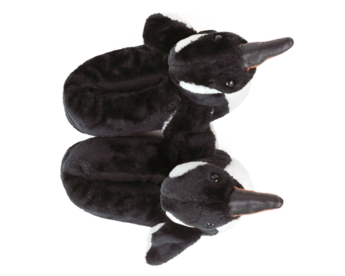 Two plush penguins slippers seen from above against a white background